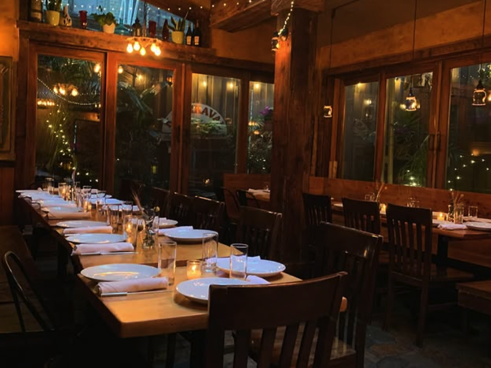 Conservatory style private dining room with low lighting and candles