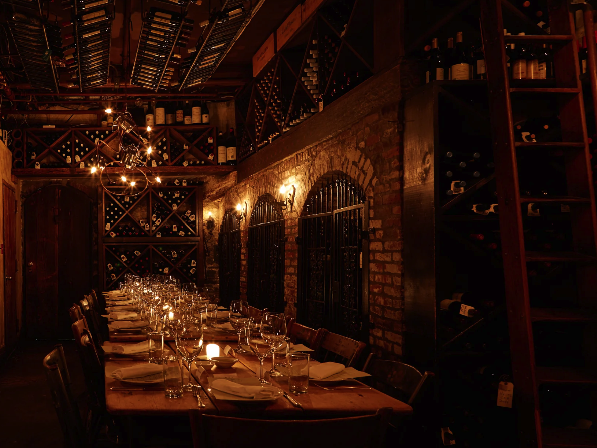Low light private dining space with a tabe setting and wine glasses