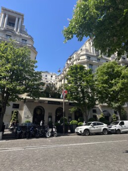 Exterior of Four Seasons Hotel George V in Paris with white cars parked